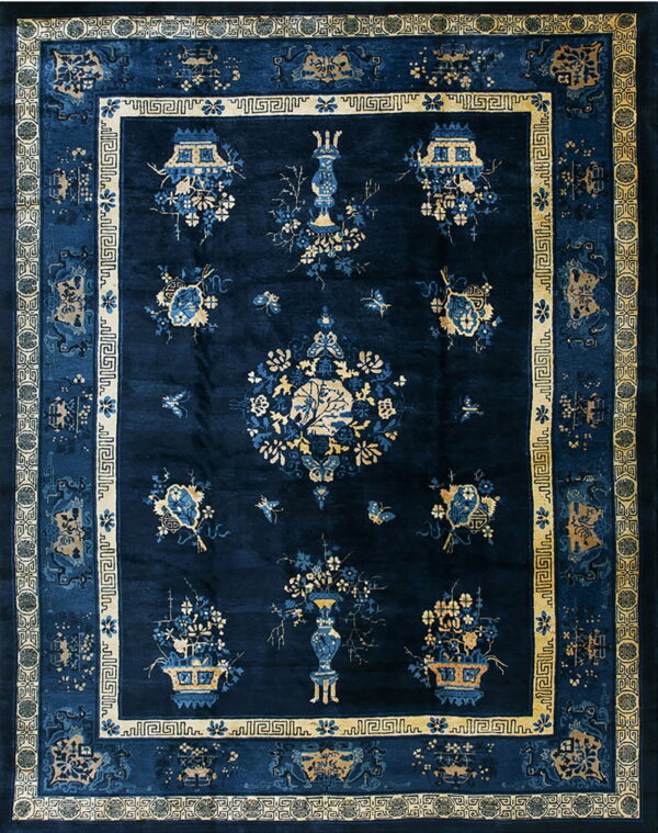 Navy blue rug featuring ornate gold borders and a field with stylized blue and tan floral and vase motifs.