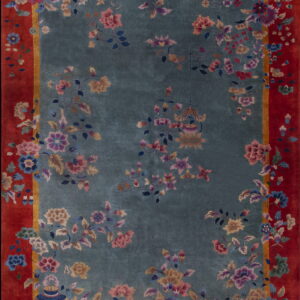 Teal and red rug featuring high pile and elaborate multicolored floral and vase patterns.