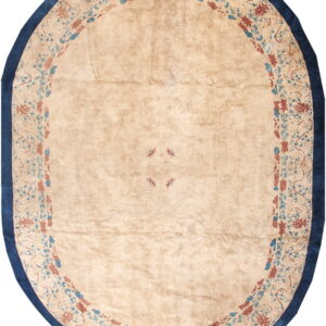 Oval beige rug featuring a blue and rust floral medallion border and a solid dark blue outer edge.