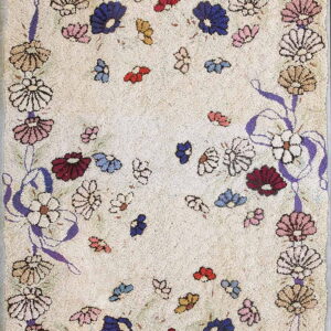 Light beige textured rug displaying a dense multicolored floral border connected by looping purple ribbons.