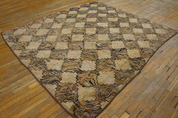 Textured, diamond-shaped rug with a beige and multicolored zigzag checkerboard design on wood floors.