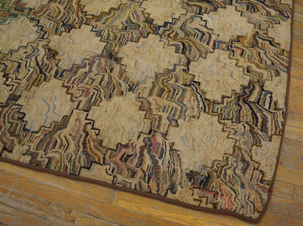 Textured beige rug with a multicolored abstract zigzag pattern on distressed wood plank flooring.