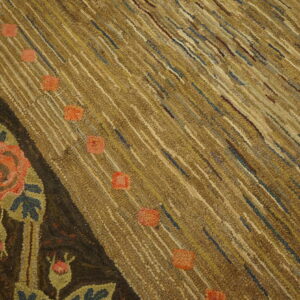 Textured brown and tan rug with diagonal striping, salmon spots, and a dark border with large floral motifs.