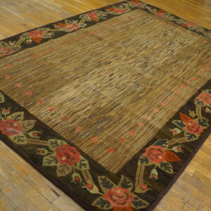 High-texture brown rug with diagonal stripes and a dark floral rose border on hardwood floors.