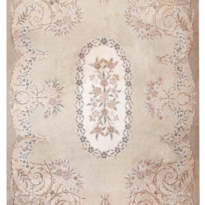 Low-pile beige rug with a detailed floral medallion and scrolling blush and gray traditional border.