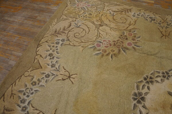 Textured sage rug with a detailed floral and vine pattern lies on distressed wooden floorboards.