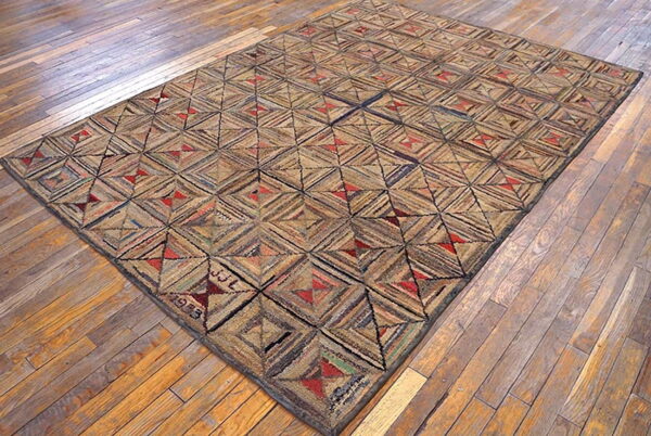 Rustic low-pile rug featuring a geometric patchwork pattern of tan, brown, and red on distressed wood planks.