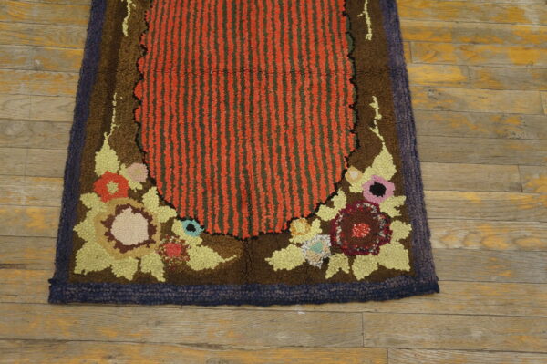 High-pile rug with a red and green striped center, colorful floral motifs, and a dark border on wood floor.
