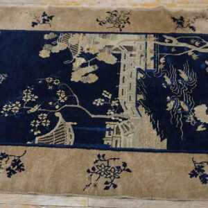 High pile rug in tan and navy blue with a detailed landscape scene on light wood floors.