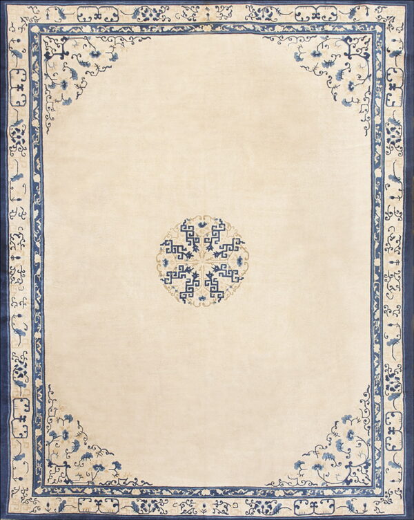 A cream rug with a geometric blue medallion and intricate blue floral border detailing.