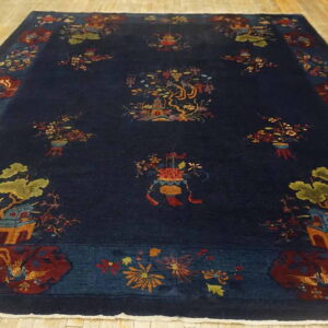 Dark navy rug featuring a complex pattern of multi-colored pagodas, trees, and flowers on light wood planks.
