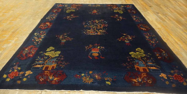 Dark navy rug featuring a complex pattern of multi-colored pagodas, trees, and flowers on light wood planks.