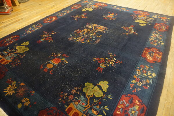 A plush navy blue rug featuring scattered colorful floral and landscape vignettes on light wood flooring.