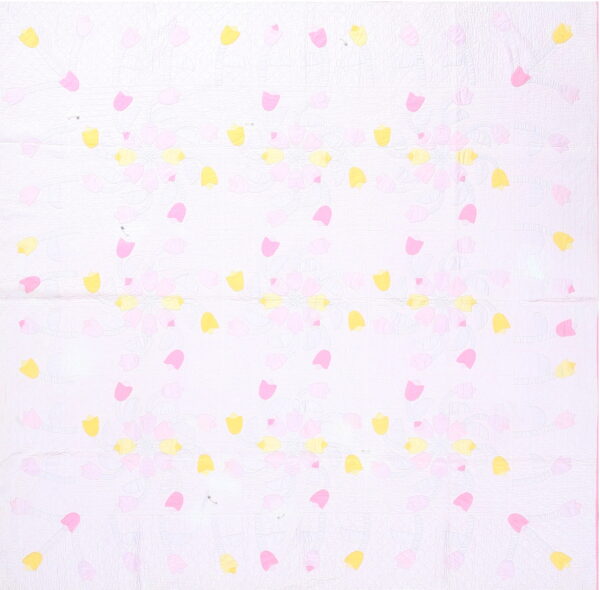 A quilted white rug features scattered bright pink and yellow tulip shapes with visible surface stitch texture.