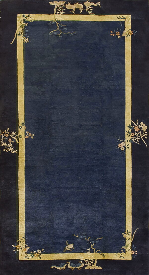 Deep blue rug with a gold inner border framed by a dark edge featuring birds and floral patterns.