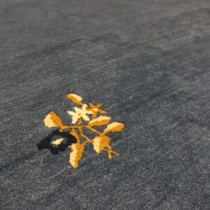 Blue area rug features a detailed floral pattern in gold, creamy white, and navy.