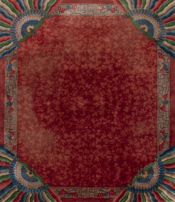 Burgundy rug with faint floral pattern, framed by multicolored borders featuring ornate fan and bird designs.