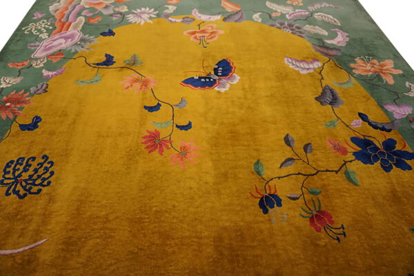 Gold and moss green rug detailed with colorful vines, large floral sprays, and a prominent blue butterfly motif.