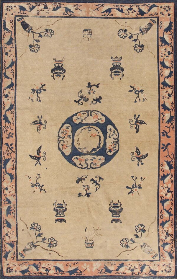 Tan rug featuring a navy blue center medallion, stylized vases, and scattered birds within a peach border.