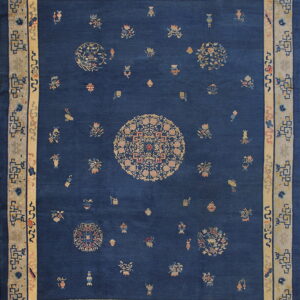 Navy blue rug with a beige medallion, scattered patterns, and a wide geometric and floral border.