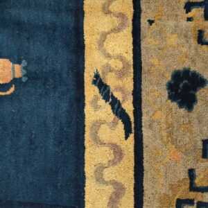 High-pile rug section in deep blue and gold, displaying winding serpentine shapes and geometric motifs.
