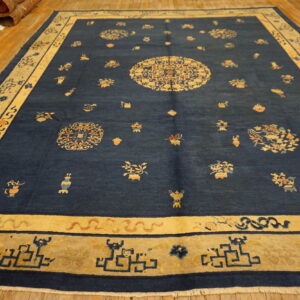 Large navy blue rug featuring a central gold medallion and scattered traditional motifs on wood planks.