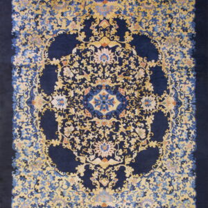 Ornate navy blue rug with a dense golden yellow floral and vine pattern around a central medallion.
