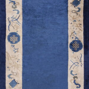 Blue runner rug featuring a wide beige border decorated with blue and tan symbolic medallions and plant motifs.