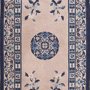 Narrow blush runner rug with dense blue geometric and floral borders surrounding blue central medallions.