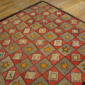 Rustic red and gray geometric rug featuring yellow stars and multi-colored patched square motifs on wood.