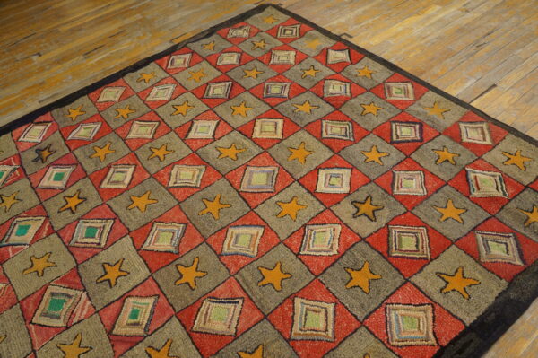 Rustic red and gray geometric rug featuring yellow stars and multi-colored patched square motifs on wood.