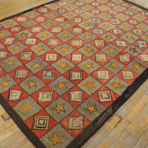 Red, gray, and yellow diamond-pattern rug with stars and squares laid diagonally on rustic wood planks.