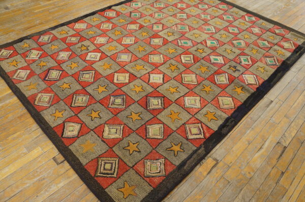 Red, gray, and yellow diamond-pattern rug with stars and squares laid diagonally on rustic wood planks.