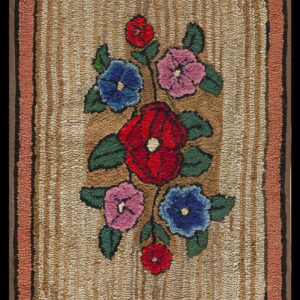 Textured rug with red, blue, and pink floral designs on a tan striped field and coral border.