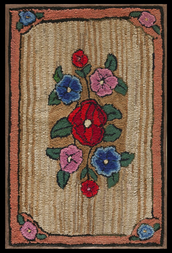 Textured rug with red, blue, and pink floral designs on a tan striped field and coral border.