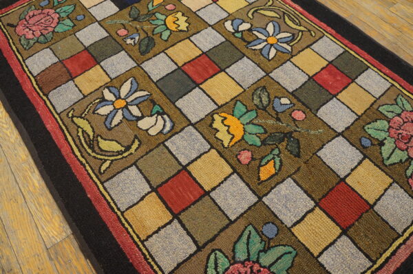 Textured, multicolored rug featuring bold floral motifs over a diagonal checkerboard pattern on wood flooring.