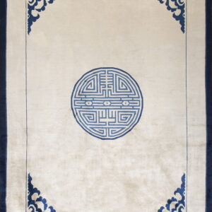 Light beige rug with a blue central medallion, ornate blue corner motifs, and a solid navy border.