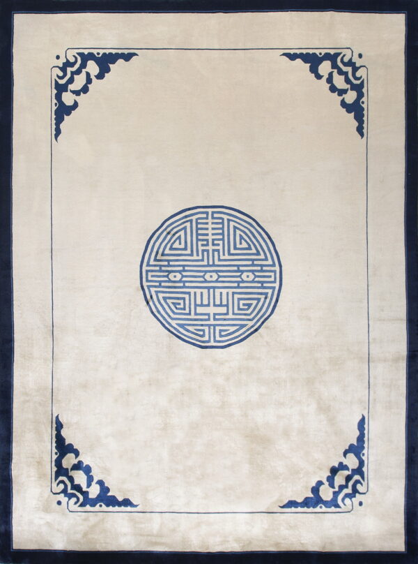 Light beige rug with a blue central medallion, ornate blue corner motifs, and a solid navy border.