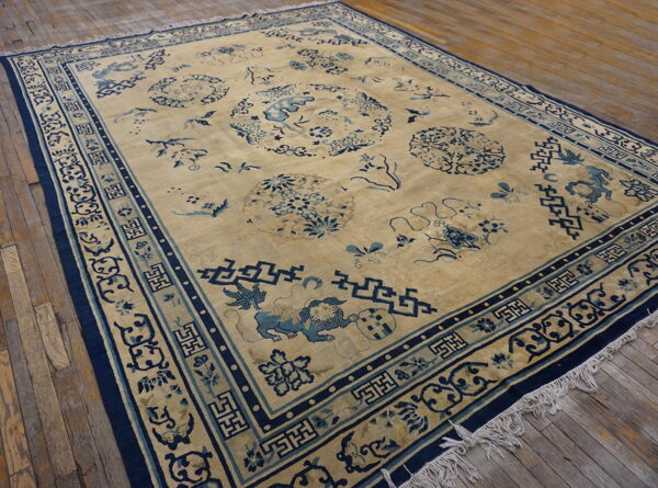 A large tan rug features detailed blue medallions and geometric borders on rustic wooden floorboards.