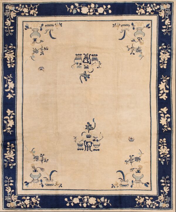 Cream rug featuring deep blue stylized motifs and a wide floral border on rustic wooden plank flooring.