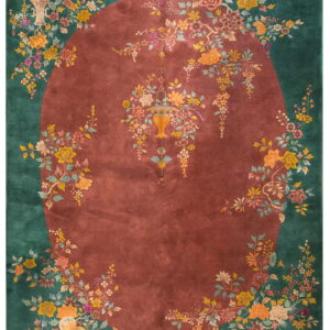 Dark green and maroon rug with a central oval and vibrant floral vines bordering the edge.