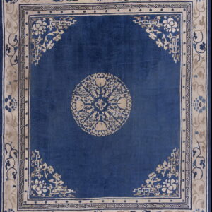 Deep blue rug featuring a beige central medallion and ornate floral and geometric borders.