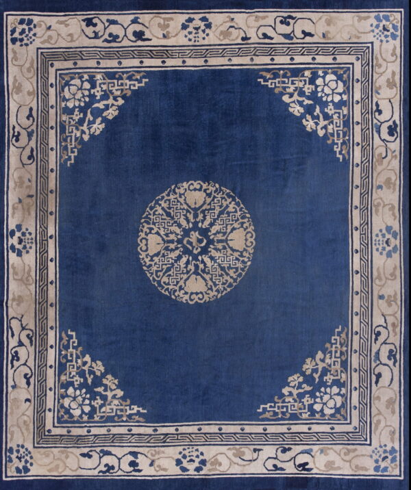 Deep blue rug featuring a beige central medallion and ornate floral and geometric borders.