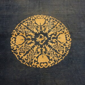 Deep blue rug featuring a prominent circular gold and tan medallion with detailed patterns.