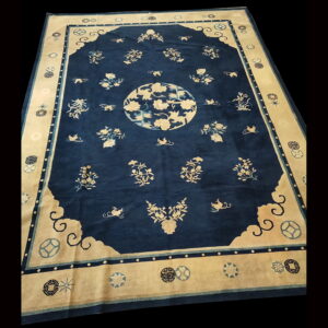 Deep blue rug featuring pale floral motifs, a central medallion, and a wide stylized border.