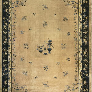 Rectangular beige rug with dark blue borders and stylized central vase and scattered floral designs.