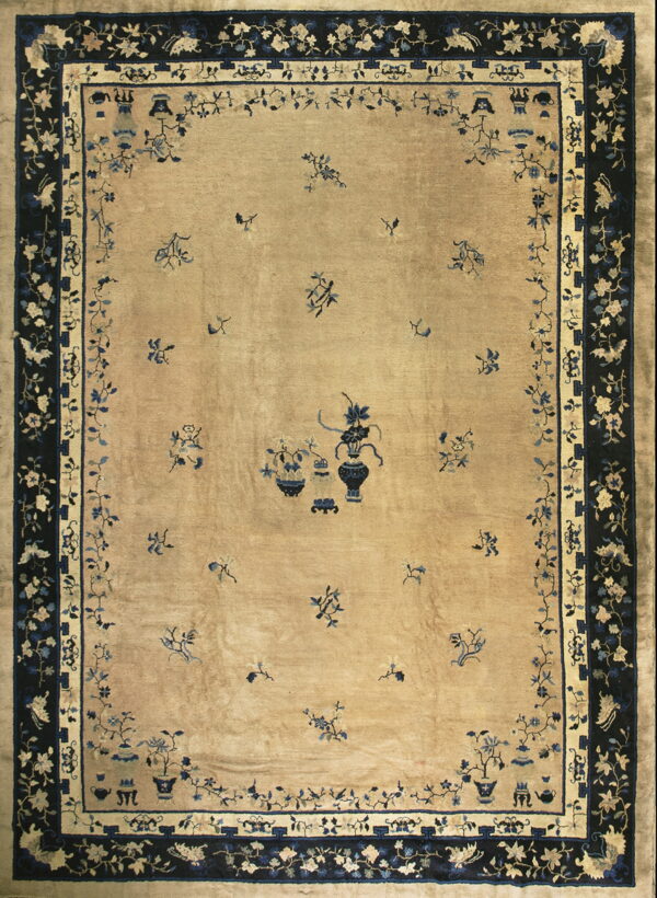 Rectangular beige rug with dark blue borders and stylized central vase and scattered floral designs.