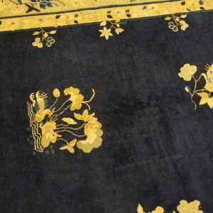 Dark blue rug features yellow floral sprays and stylized animal patterns with a golden yellow border.
