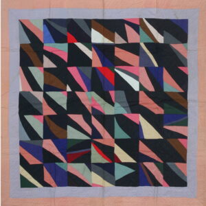 Geometric textile with colorful triangular patches on a dark background and pale pink and purple quilted borders.