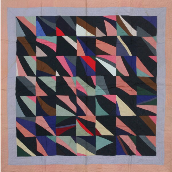 Geometric textile with colorful triangular patches on a dark background and pale pink and purple quilted borders.